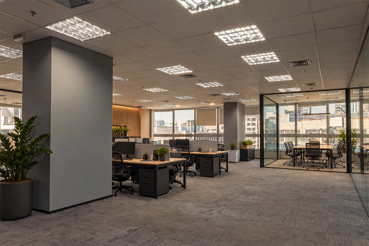 Sala corporativa ambientada com estações de trabalho, plantas e sala de reunião